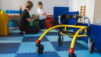 An educator assisting a child to use a walking aid