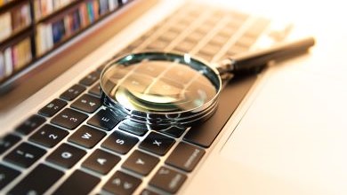 Magnifying glass resting on a keyboard in a library